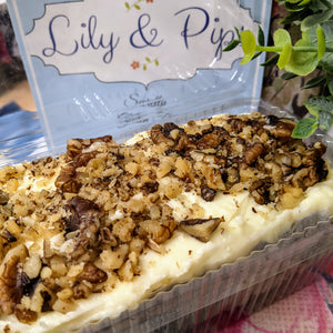 Whole one pound carrot cake shown inside the clamshell it ships in.