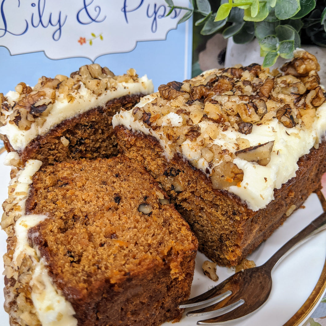 Carrot Cake sliced to show texture of frosting along with walnuts and flecks of carrot in the cake.